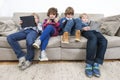Brothers And Sister Using Technologies On Sofa