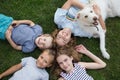 Brothers and sisters of different ages lie on the grass, looking up Royalty Free Stock Photo