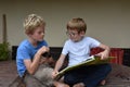 Brothers and their cat looking a book Royalty Free Stock Photo