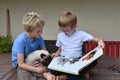 Brothers and their cat looking a book Royalty Free Stock Photo