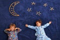Brothers to the moon and back. Two young boys lying underneath a imaginary moon and stars. Royalty Free Stock Photo