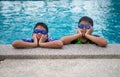 brothers wearing swimsuits and glasses Smile while perched on the edge of the pool Royalty Free Stock Photo