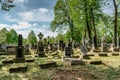 Broumov, Czech republic - May 21, 2021. Renaissance and Empire style tombstones and graves in old cemetery with wooden Church Of