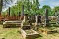 Broumov, Czech republic - May 21, 2021. Renaissance and Empire style tombstones and graves in old cemetery with wooden Church Of