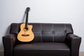 brown acoustic guitar on sofa