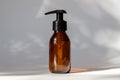 Brown amber glass bottle with lotion pump dispenser. Cosmetic container for shampoo, essential oil, lotion soap
