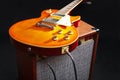 Brown amplifier for guitar with honey sunburst guitar on black background Royalty Free Stock Photo