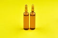 Brown ampoules with medicine on yellow background Royalty Free Stock Photo