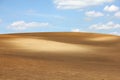 Brown arable hill against blue sky Royalty Free Stock Photo