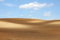 Brown arable hills against blue sky Royalty Free Stock Photo