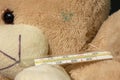 Brown baby teddy bear with thermometer close-up