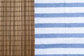 Brown bamboo mat on table cloth with blue stripe. Royalty Free Stock Photo