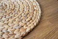 A brown bamboo wicker mat on a sturdy wooden table