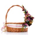 Brown basket with floral decor on one side of the handle. Isolated on white.