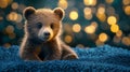 Cute brown bear cub resting on soft surface with glowing bokeh background in a cozy setting Royalty Free Stock Photo