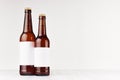 Brown beer bottles longneck 500ml and 330ml with blank white label on white wooden board, mock up.