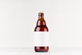 Brown belgian steinie beer bottle 500ml with blank white label on white wooden board, mock up. Royalty Free Stock Photo