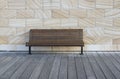 Brown bench on wooden deck with sandstones wall background