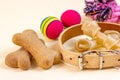 Brown biscuit bones for dogs in a beige collar with toys on light background. Dog and puppy food, healthy treats.