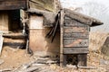 Brown and black burnt house of wooden planks with embossed texture without door and broken wall. damage to the building from fire Royalty Free Stock Photo