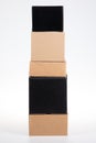 Brown black cardboard boxes stacked on each other pyramid on white grey background