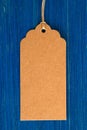 Brown blank paper price tag or label set on the blue wooden background. Royalty Free Stock Photo