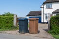 Brown and blue wheelie bins outside a house. UK