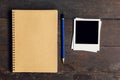 Brown book and pencil with frame photo on wood table background