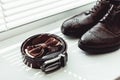 Brown bow tie, leather shoes and belt. Grooms wedding morning. Close up of modern man accessories