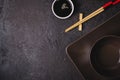 Brown bowls, soy sauce and bamboo chopsticks. Asian table setting Royalty Free Stock Photo