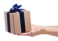 Brown box with blue ribbon bow gift in hand Royalty Free Stock Photo