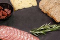 Brown bread, dutch gouda cheese, rosemary and meat on slate board Royalty Free Stock Photo