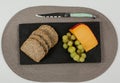 Brown bread, grapes and gouda cheese with knife on slate board Royalty Free Stock Photo