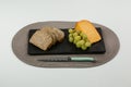 Brown bread, grapes and gouda cheese with knife on slate board Royalty Free Stock Photo
