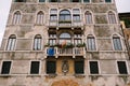 Brown brick stone wall, house facade in Italy, Venice, with old classic Venetian windows with a stone balcony, with a Royalty Free Stock Photo