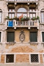 Brown brick stone wall, house facade in Italy, Venice, with old classic Venetian windows with a stone balcony, with a Royalty Free Stock Photo