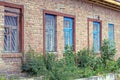 Brown brick wall of an old rural house with a row of windows Royalty Free Stock Photo