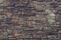 Brown brick wall. Stone weathered backdrop, granite facade surface, rock textured. Decorative dirty tiles on the wall. Grunge urba Royalty Free Stock Photo