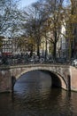 Brown bridge with bikes over the canal in autumn in Amsterdam Royalty Free Stock Photo