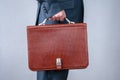 Brown briefcase in hand businessman side view