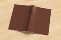 Brown brochure or booklet cover mock up on wooden background. Brochure is open and upside down. Isolated with clipping path around Royalty Free Stock Photo