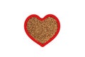 Brown buckwheat groats in heart shape red frame isolated on white.