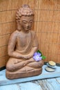 Brown Buddha statue with bamboo reed background