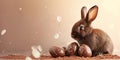 Brown bunny sits beside speckled chocolate eggs on a cocoa-dusted background, evoking an adorable and cozy Easter scene Royalty Free Stock Photo