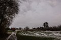 Brown cabin on the icy green field in winter