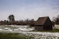 Brown cabin on the icy green field in winter