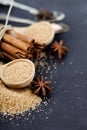 Brown cane sugar, cinnamon sticks and star anise closeup on black board background Royalty Free Stock Photo