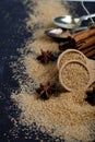 Brown cane sugar, cinnamon sticks and star anise closeup on black board background Royalty Free Stock Photo