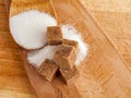 Brown cane sugar in cubes and white crystalline sugar, top view, types