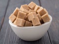 Brown cane sugar in a white Cup on a brown wooden background, si